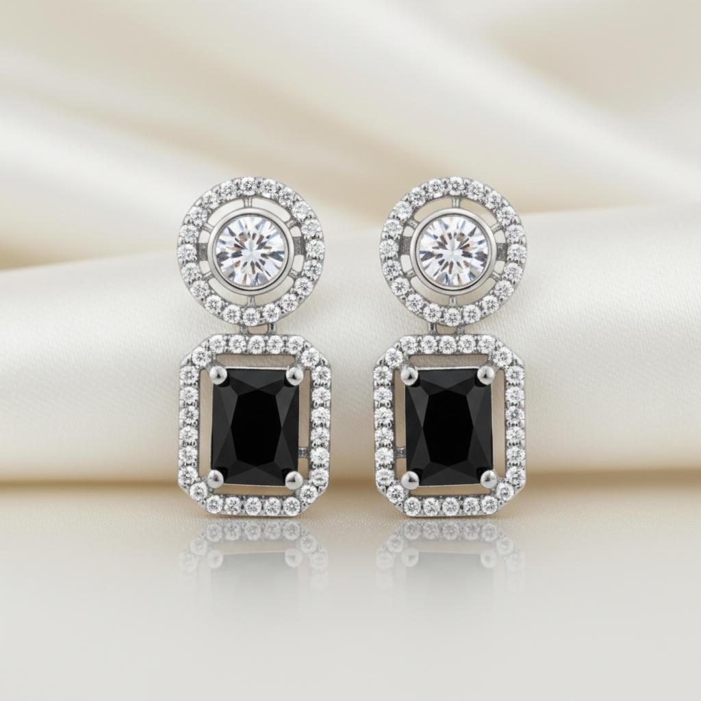 Elegant rhodium plated dangle earrings featuring a round halo stud and a large, emerald-cut black gemstone surrounded by a halo of brilliant American Diamonds (AD). Perfect for parties and formal events.