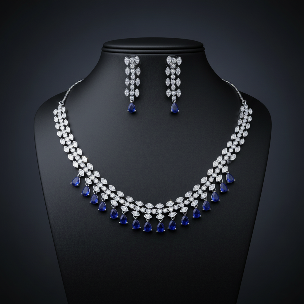 Elegant marquise leaf vine necklace set with American Diamonds (AD) and dangling pear-shaped gemstone drops, shown in sapphire blue. Available in red, green, blue, pink, and white. Rhodium plated party wear jewellery for weddings and receptions.