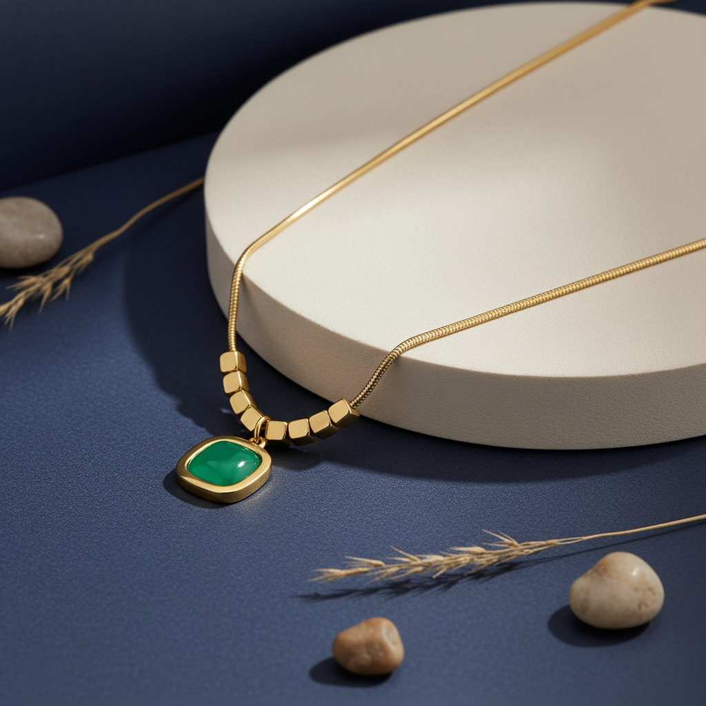 Minimalist gold plated snake chain necklace featuring a smooth square cushion-cut gemstone pendant and decorative cube beads. Available in Green, Peach, and Pink. Modern daily wear jewellery for women. Minimalist Necklace, Gold Plated Necklace, Square Pendant, Cushion Cut Necklace, Snake Chain, Cube Beads, Daily Wear Jewellery, Office Wear Necklace, Stone Pendant, Modern Necklace, Vrumaira, Surat Jewellery, Green Stone Necklace, Pink Stone Necklace, Peach Stone Necklace, Rose Quartz Look, Emerald Look