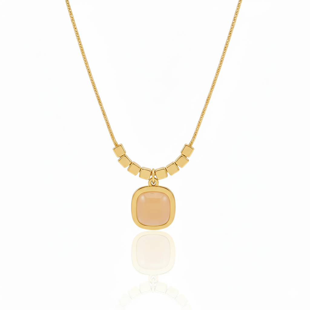 Minimalist gold plated snake chain necklace featuring a smooth square cushion-cut gemstone pendant and decorative cube beads. Available in Green, Peach, and Pink. Modern daily wear jewellery for women. Minimalist Necklace, Gold Plated Necklace, Square Pendant, Cushion Cut Necklace, Snake Chain, Cube Beads, Daily Wear Jewellery, Office Wear Necklace, Stone Pendant, Modern Necklace, Vrumaira, Surat Jewellery, Green Stone Necklace, Pink Stone Necklace, Peach Stone Necklace, Rose Quartz Look, Emerald Look